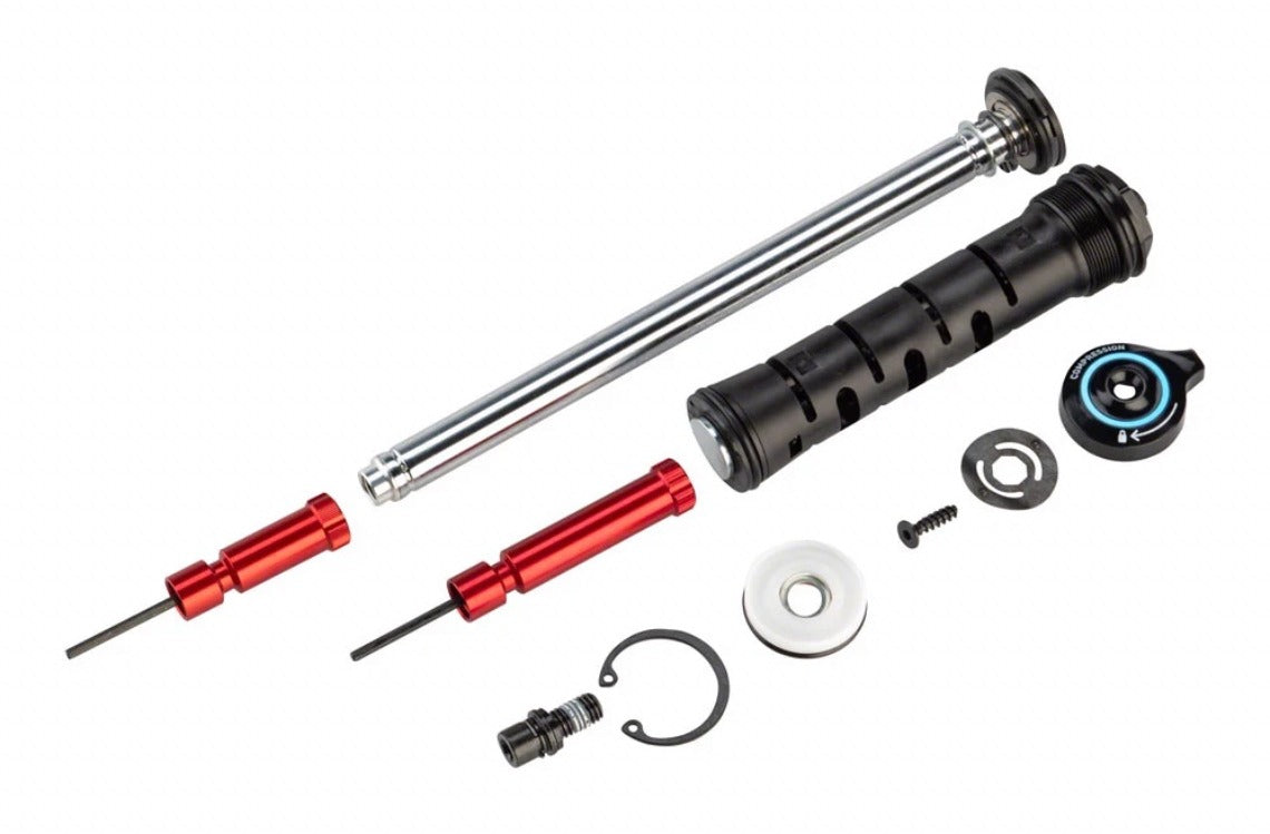 RockShox Charger Race Day damper upgrade kit components laid out on white: damper shaft and body, red adjustment tools, seals, snap ring, and mounting hardware.
