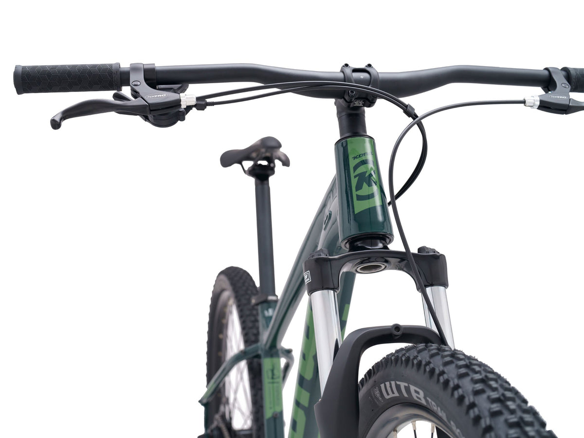 Kona Fire Mountain 2026 hardtail mountain bike in Gloss Emerald green, close-up front view of handlebar, cockpit, and fork