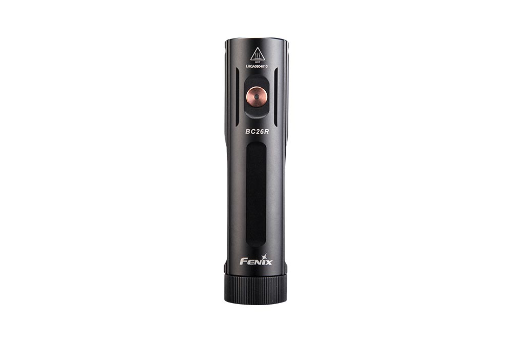 Fenix BC26R bike light top view showing copper power button, BC26R marking, hot surface warning symbol, and Fenix branding on black aluminum body
